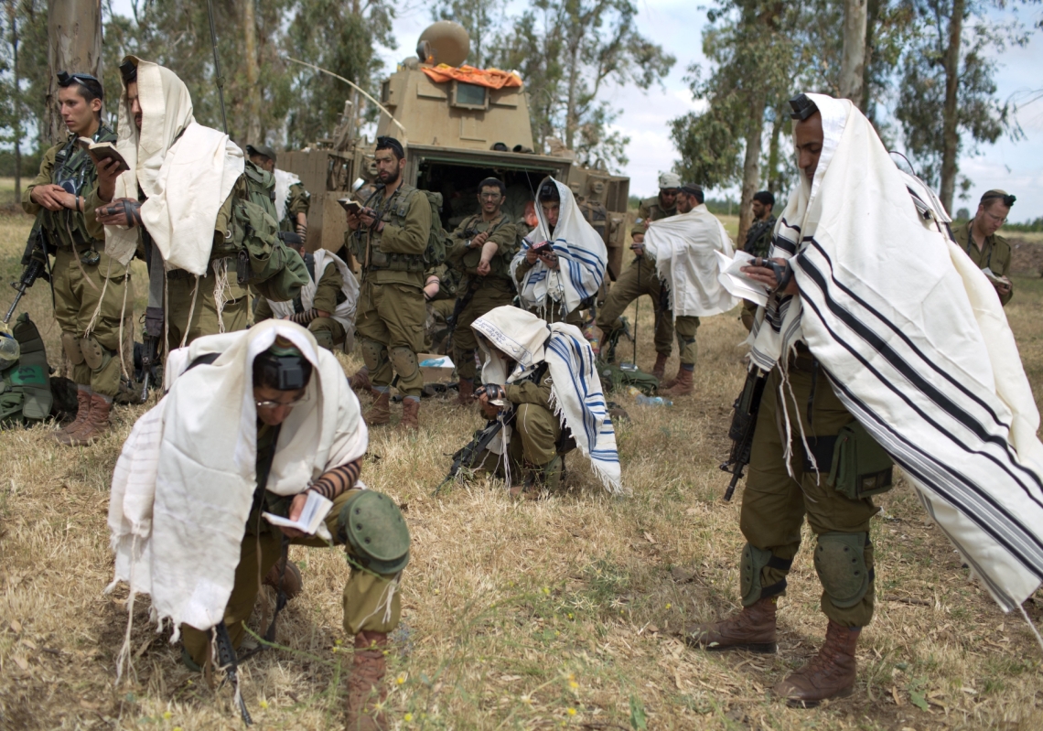 Israeli soldiers of the Jewish Ultra-Orthodox battalion "Netzah Yehuda" hold morning prayers as they take part in their annual unit training in the Israeli-occupied Golan Heights, near the Syrian border on May 19, 2014.