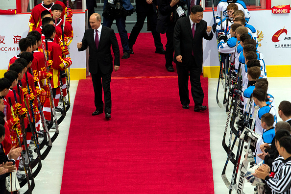Russian President Vladimir Putin (C-L) and Chinese President Xi Jinping greet players from Chinese and Russian youth Ice Hockey teams before a friendly match on June 8, 2018 in Tianjin, China. (Getty)