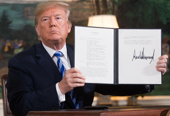 US President Donald Trump signs a document reinstating sanctions against Iran after announcing the US withdrawal from the Iran Nuclear deal, in the Diplomatic Reception Room at the White House in Washington, DC, on May 8, 2018. (Getty)