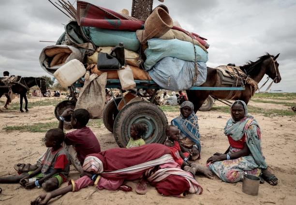A Sudanese family who fled conflict in Darfur sits next to their possessions while waiting to be registered at the crossing from Sudan to Chad on 26 July 2023. 