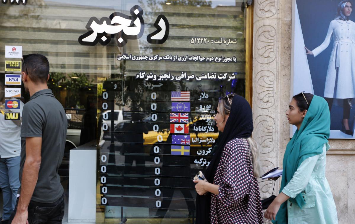  People walk in front of a currency exchange shop in the Iranian capital Tehran on August 8, 2018. (Getty)